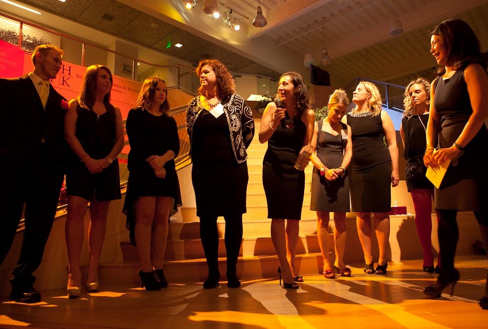 a group of gala attendees standing on a stage