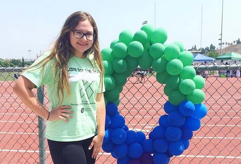 fundraiser participant standing next to balloons